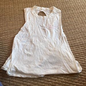 white athletic tank top. Says “do all things with love” sewn on the front